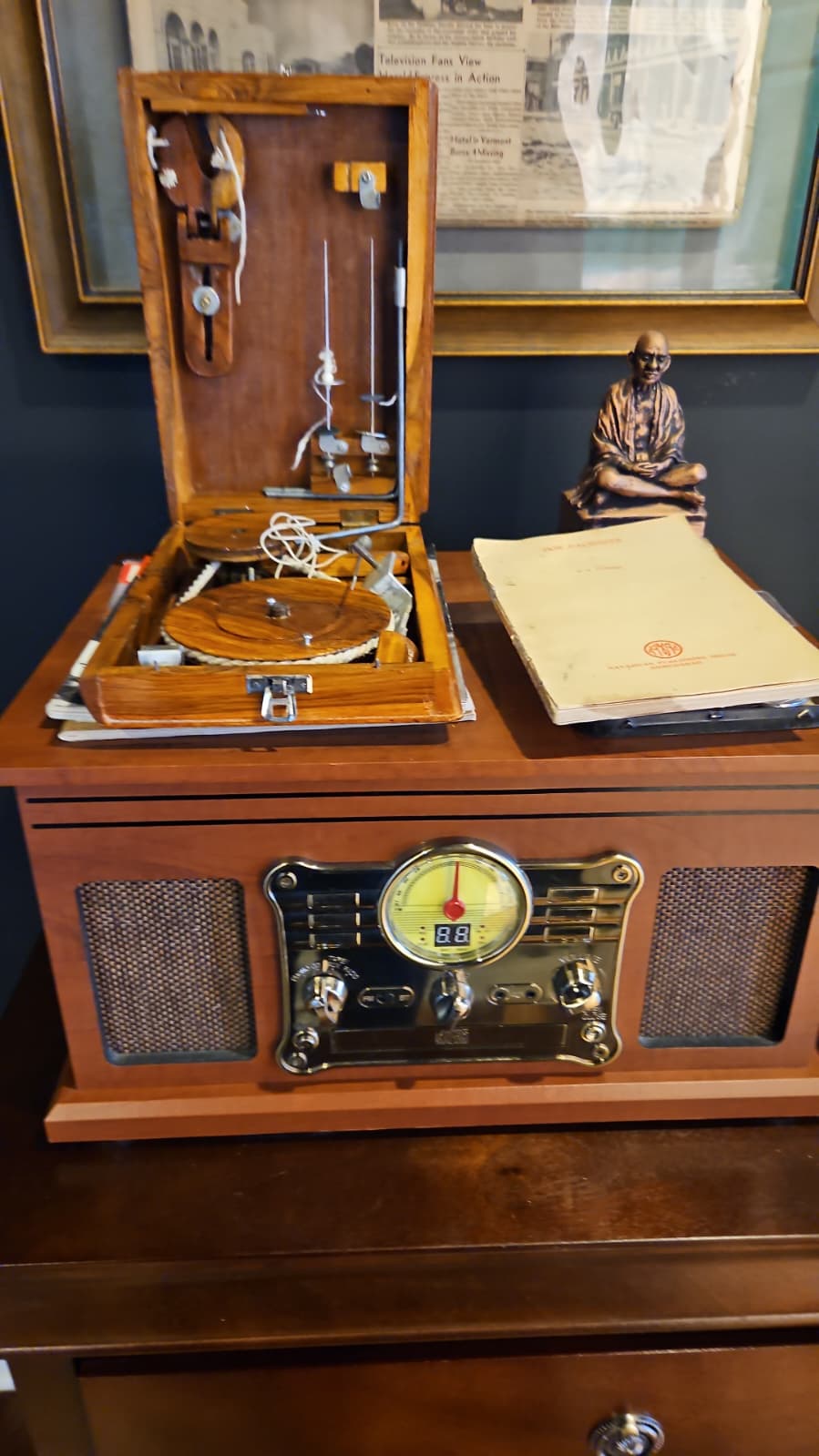 A reproduction wooden book charkha, a portable spinning wheel of the type associated with Mahatma Gandhi, in a wooden box